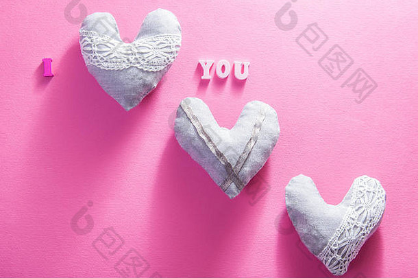 在<strong>粉色</strong>纸背景上刻有“我爱你”字样的心。情人节的概念。