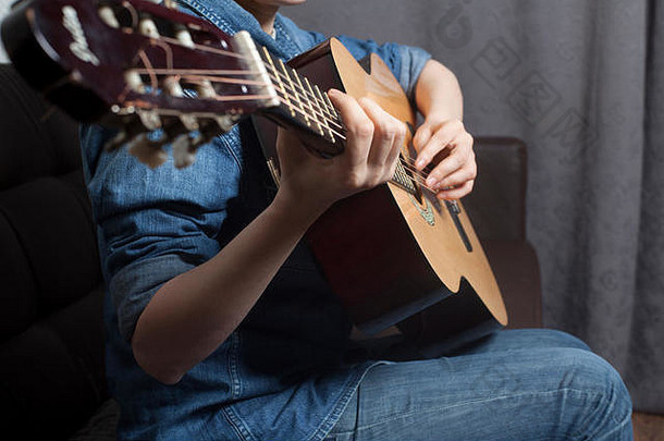 年轻女奏古典吉他的手