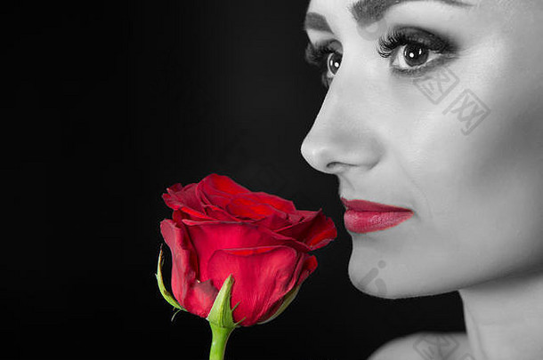 红唇妆的女人捧着玫瑰。花的美丽。感官美。娇嫩如花。妇女节，黑色和<strong>白色</strong>。