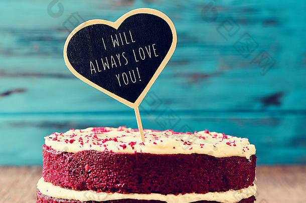 一个红色天鹅绒蛋糕的特写镜头，上面是一块心形黑板，上面写着“我将<strong>永远爱你</strong>”，写在铁锈上