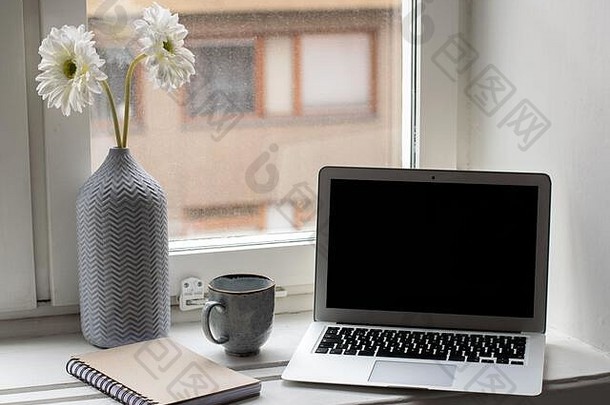 明亮的现代工作场所窗口花移动PC笔记本咖啡杯