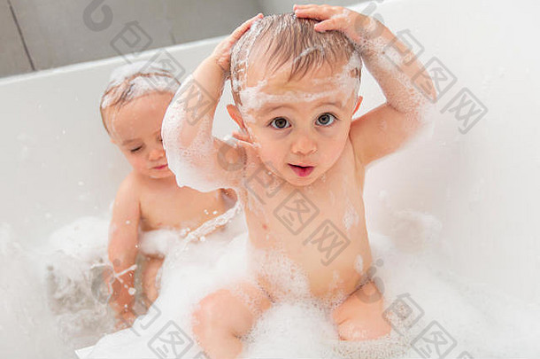 两个小男孩在浴缸里洗澡，玩水