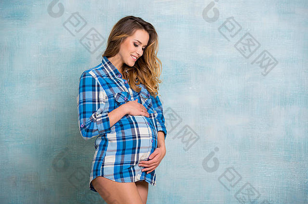 关闭年轻的怀孕了女人微笑拥抱肚子女孩穿着格子衬衫