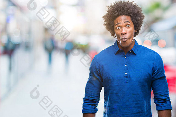 孤立背景下的美国黑人男子用嘴唇做鱼脸，疯狂滑稽的手势。滑稽的表情。