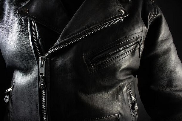 黑色背景上黑色皮夹克的特写照片。
