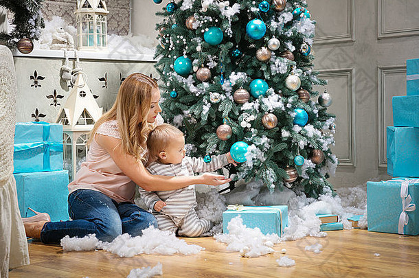 年轻女子和她的小儿子在触摸<strong>圣诞</strong>树上的小装饰品
