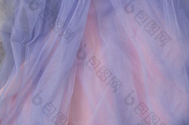粉红色背景上的蓝色薄纱面料特写。婚纱，织物质地