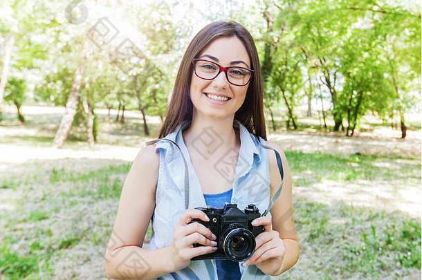 肖像快乐年轻的欧洲女人女业余摄影师古董相机公园