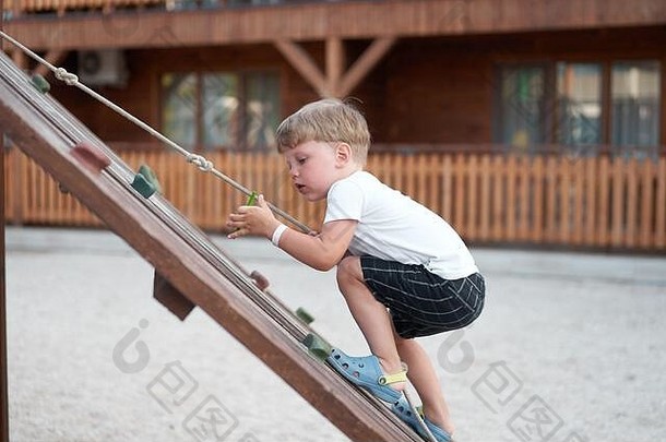 男孩玩耍游乐场儿童爬绳户外儿童健康夏季活动健康成长