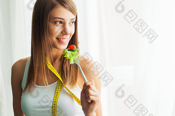 饮食健康的吃年轻的女人吃健康的沙拉锻炼