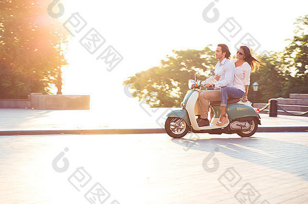这对年轻夫妇骑着摩托车玩得很开心。早晨阳光明媚