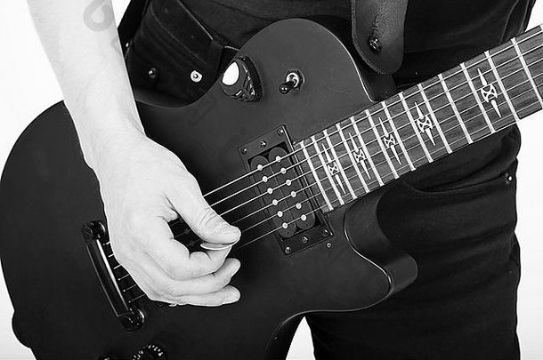 男人的手用黑色吉他特写。单色
