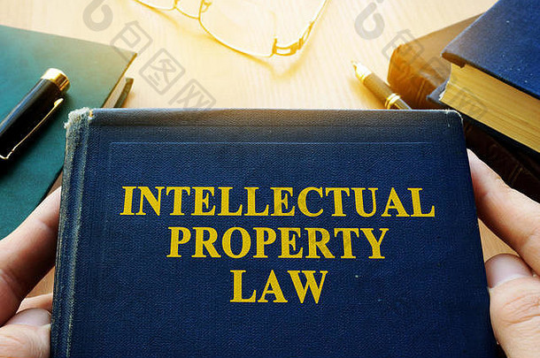 版权侵权概念。桌子上放着知识产权法和其他书籍。