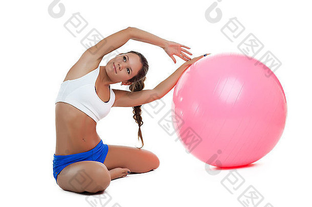 年轻女子用健身球展示伸展运动