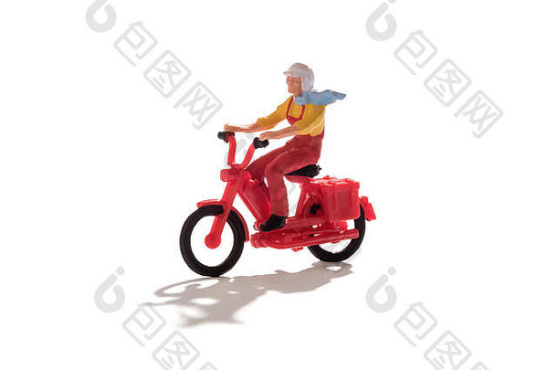 一个戴着围巾的微型男子骑着一辆五颜六色的红色摩托车，在白色的道路上与外界隔绝，留下了的空间和阴影