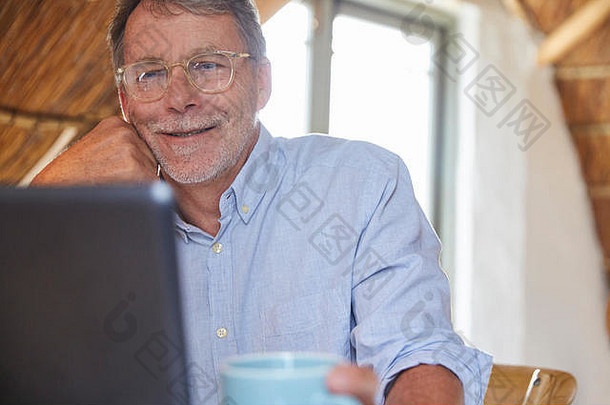 老年人喝咖啡和使用笔记本电脑