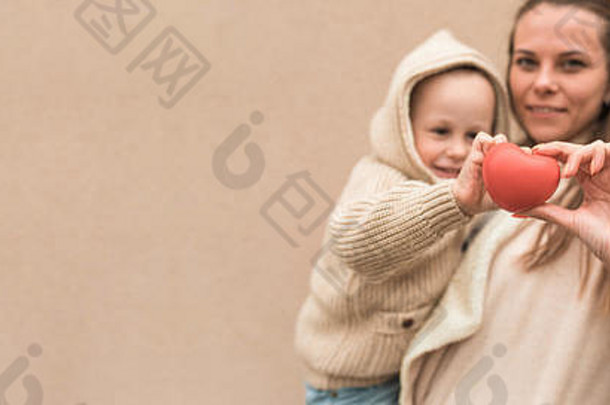 妈妈女人男孩儿子年背景墙手玩具红色的心概念给生活爱捐赠妈妈。