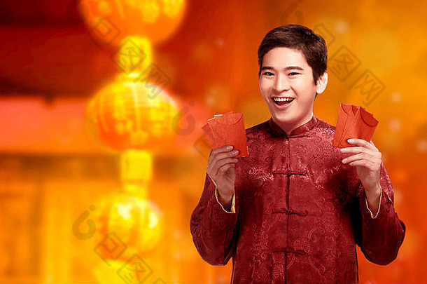 英俊的中国男子，穿着旗袍，手上拿着红包。新年快乐