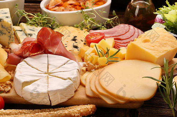 <strong>各种</strong>类型的奶酪和开胃菜板，置于乡村木板上