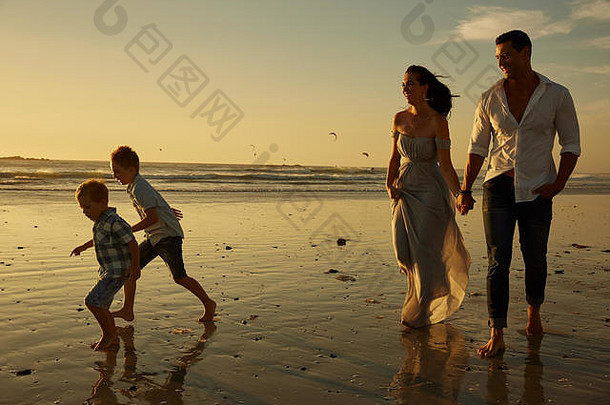 一家人和他们的孩子在阳光明媚的海滩上度假，一起享受一个非常快乐的下午。