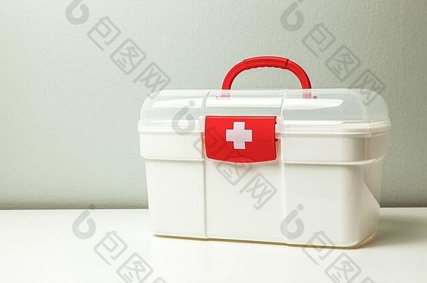 急救箱。灰色背景上带有十字架和红色扣的白色盒子。