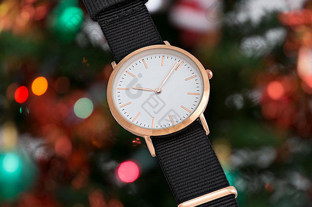 圣诞树背景灯前的黑色尼龙表带手表