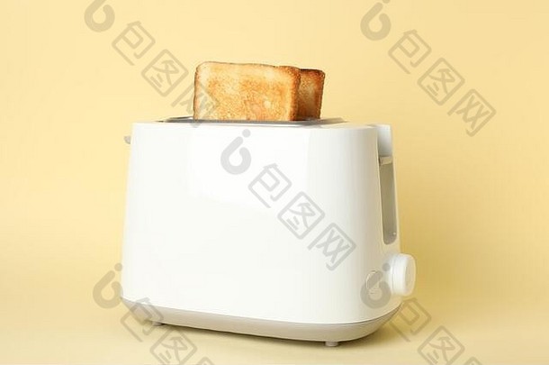 米色背景面包片烤面包机，特写