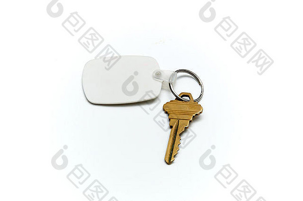 钥匙圈上的空白白色橡胶钥匙，白色表面上有一把黄铜钥匙。在fob和白色上空格。不孤立