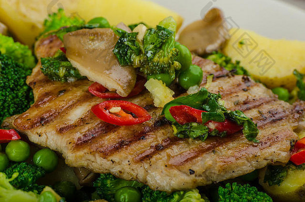 健康猪肉切痂配超级绿色蔬菜、花椰菜、豌豆、猪肉和土豆