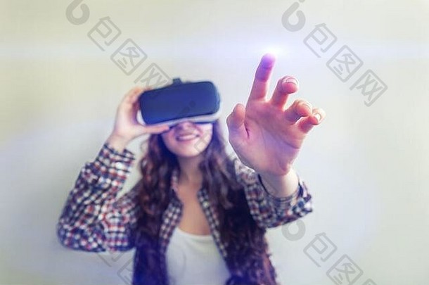 在白色背景下，戴着虚拟现实VR眼镜和头盔耳机的年轻女子微笑。智能手机使用虚拟现实护目镜。技术、模拟、高<strong>科技</strong>、电子游戏概念
