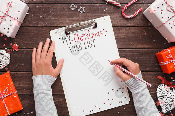 女孩写作圣诞节列表木背景