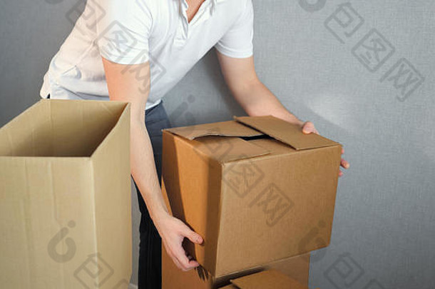 搬家日，一名年轻的送货员将箱子搬进新居