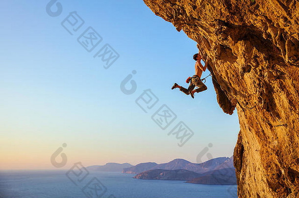 岩石登山者跳的把手攀爬突出悬崖