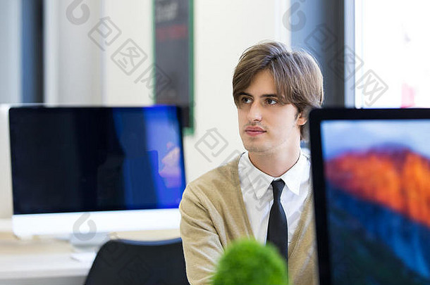 快乐的的家伙坐着前面桌面电脑