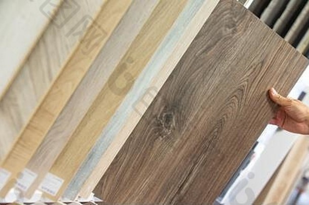 男子选择正确的颜色和材料的木地板为他的新公寓在地板工作室，家具家庭