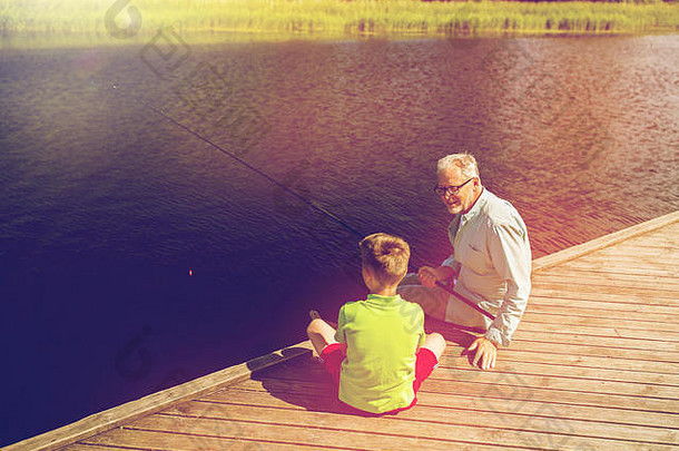 爷爷和孙子在河边的泊位上钓鱼
