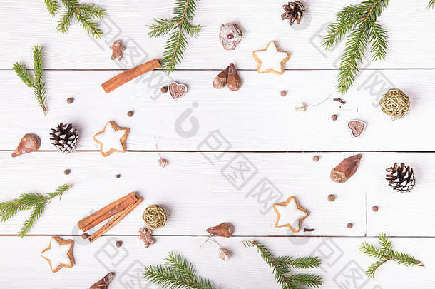 圣诞作文。木制白色背景上的圣诞纸杯蛋糕，有香料丁香、种子和坚果、记事本、钢笔、松果。平面布置，俯视图。