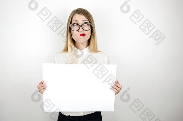 戴眼镜的年轻困惑的女商人拿着一张空白的公告纸，在空白的背景空间里写着文字