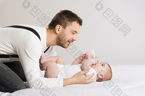 年轻的父亲喂养婴儿女儿