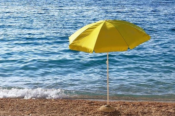 夏<strong>季</strong>海岸的黄色沙滩伞。日落时，带着太阳伞的海滩正在等待游客。快乐<strong>暑假</strong>概念。