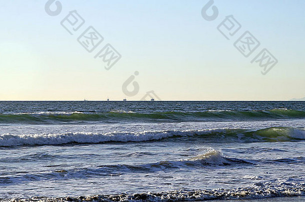 美丽的南部加州海岸线波打破海岸离岸石油钻井平台背景
