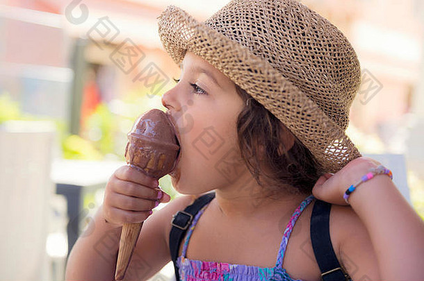 戴着草帽，穿着夏装的小女孩享受着<strong>夏日</strong>的酷热，她吃着一个<strong>清爽</strong>的冰激凌筒，冰激凌融化在她的手中，她笑得很滑稽