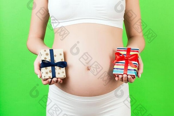 裁剪图像怀孕了女人白色内衣持有礼物盒子绿色背景男孩女孩等待双胞胎怀孕肿物