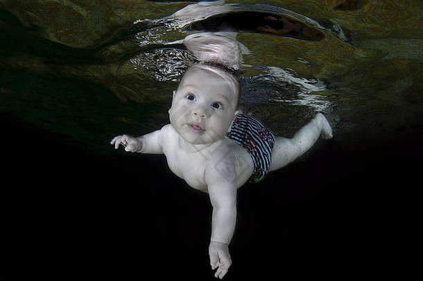 乌克兰，东欧，游泳池中的waterbaby班，5个月大的婴儿正在学习水下游泳