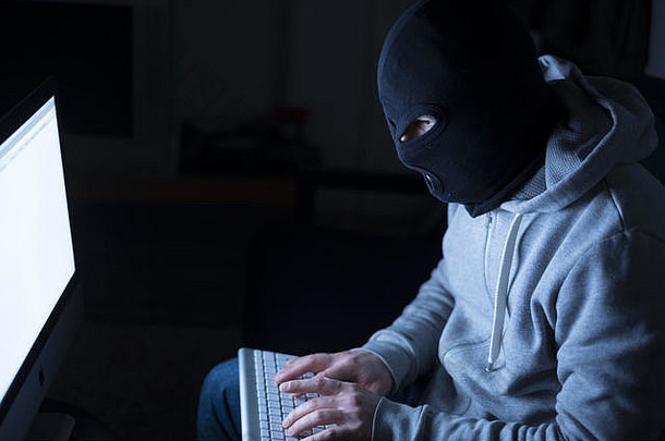 黑客穿巴拉克拉法帽晚上电脑