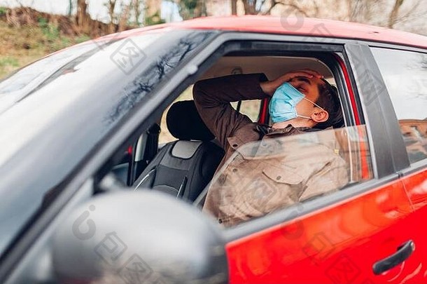 生病了男人。坐着车穿保护面具感觉发热生病的流感科维德冠状病毒受感染的的家伙抓住了冷