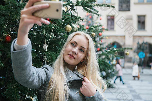美丽的年轻的金发女郎女人女孩自拍拍摄圣诞节树圣诞节假期小镇广场布拉格捷克共和国