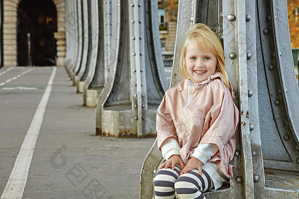 一年轮适合臀部巴黎肖像微笑健康的孩子体育运动风格衣服坐着甲板a-hakeim桥