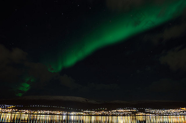 北极圈上空的北极光在雪山峡湾水中的反射