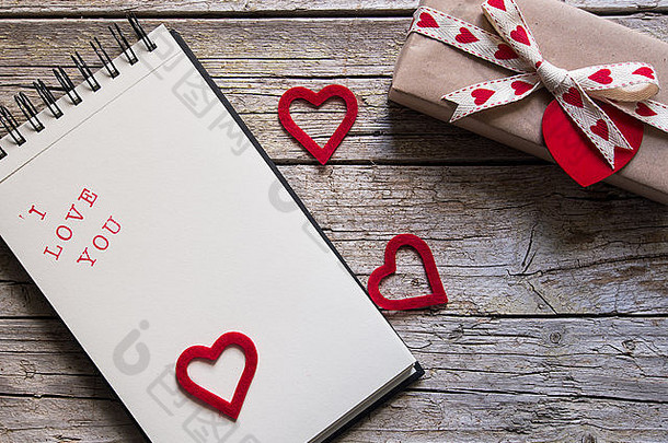 情人节礼品盒、<strong>笔记本</strong>和木板上的红色心形标签